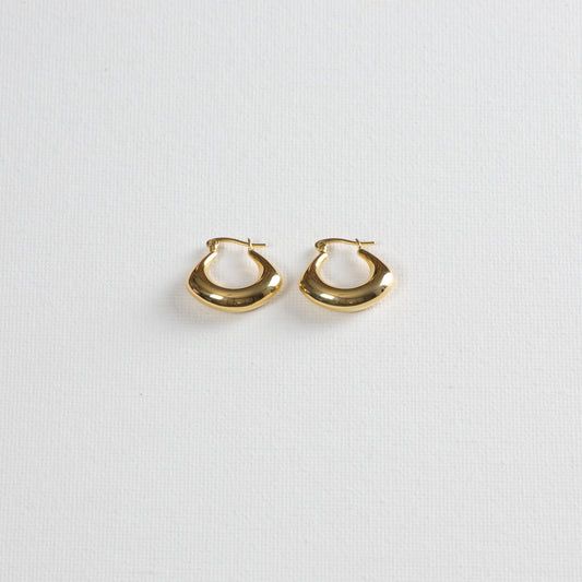 Spade earrings placed on a white background, photographed from a slight angle from the bottom.