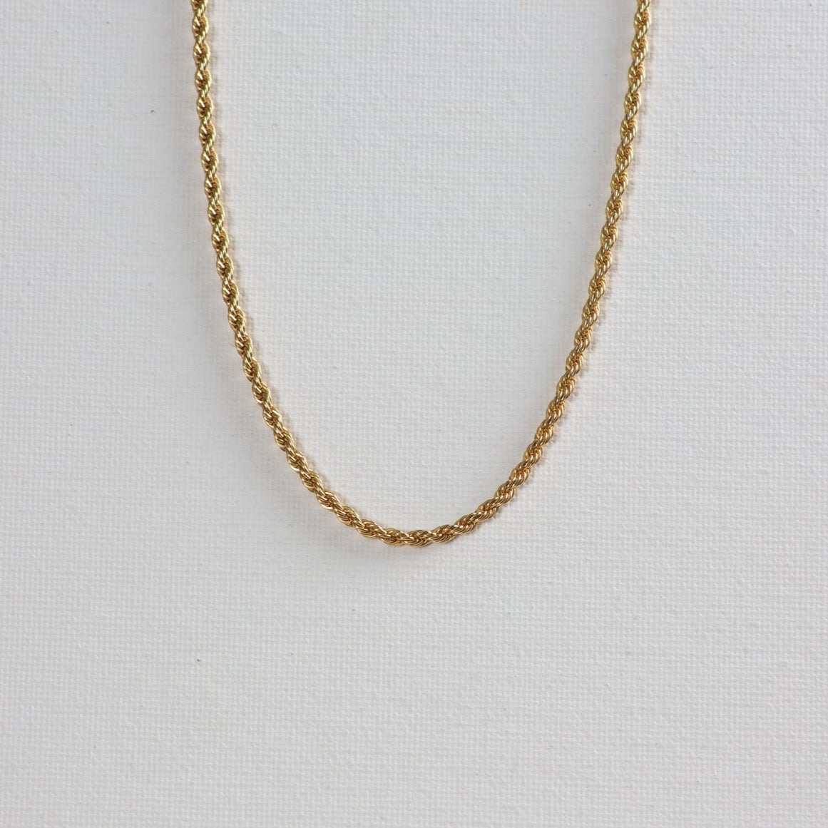 The twisted gold necklace on a white background.