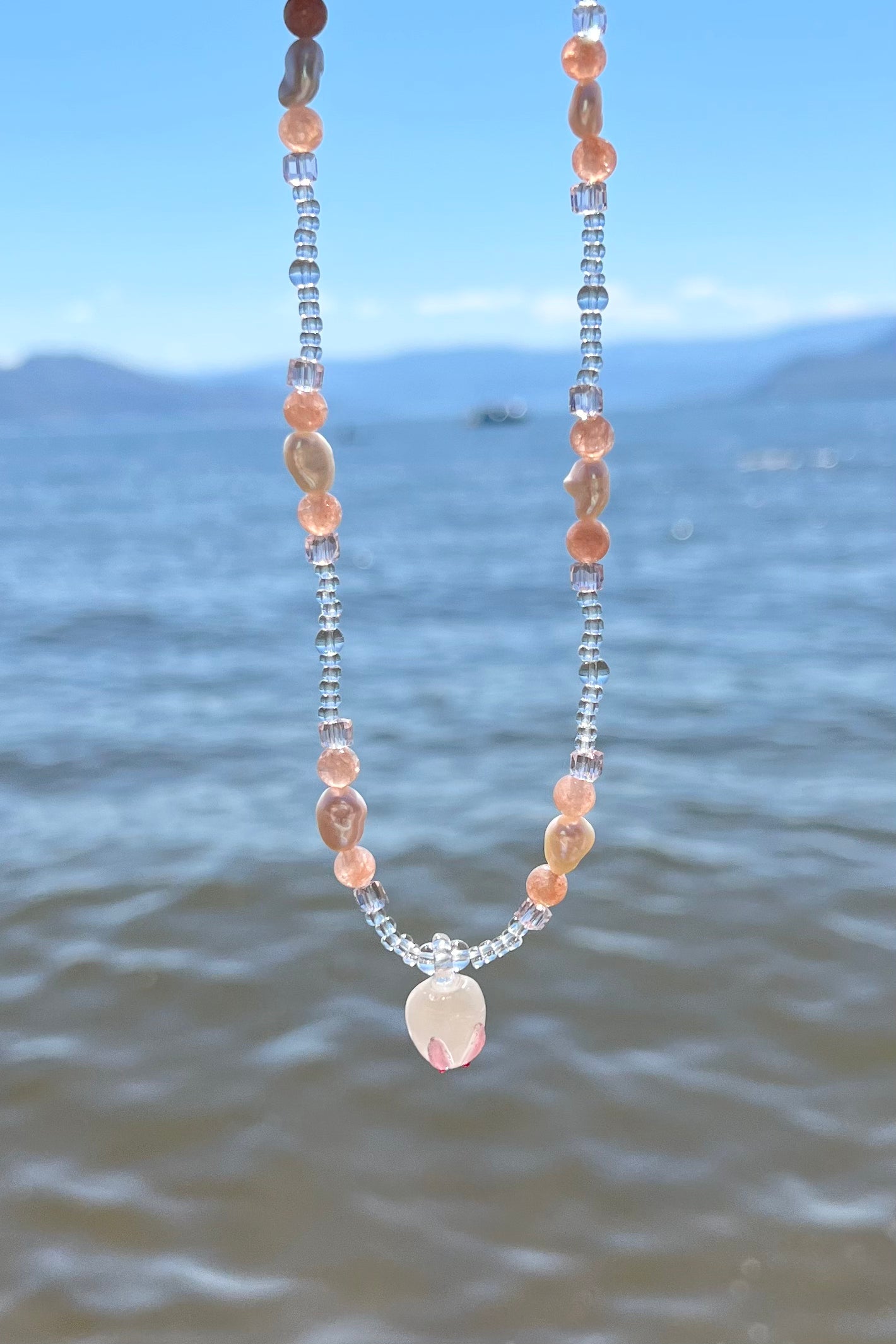The bunny bead necklace photo taken on a beach.