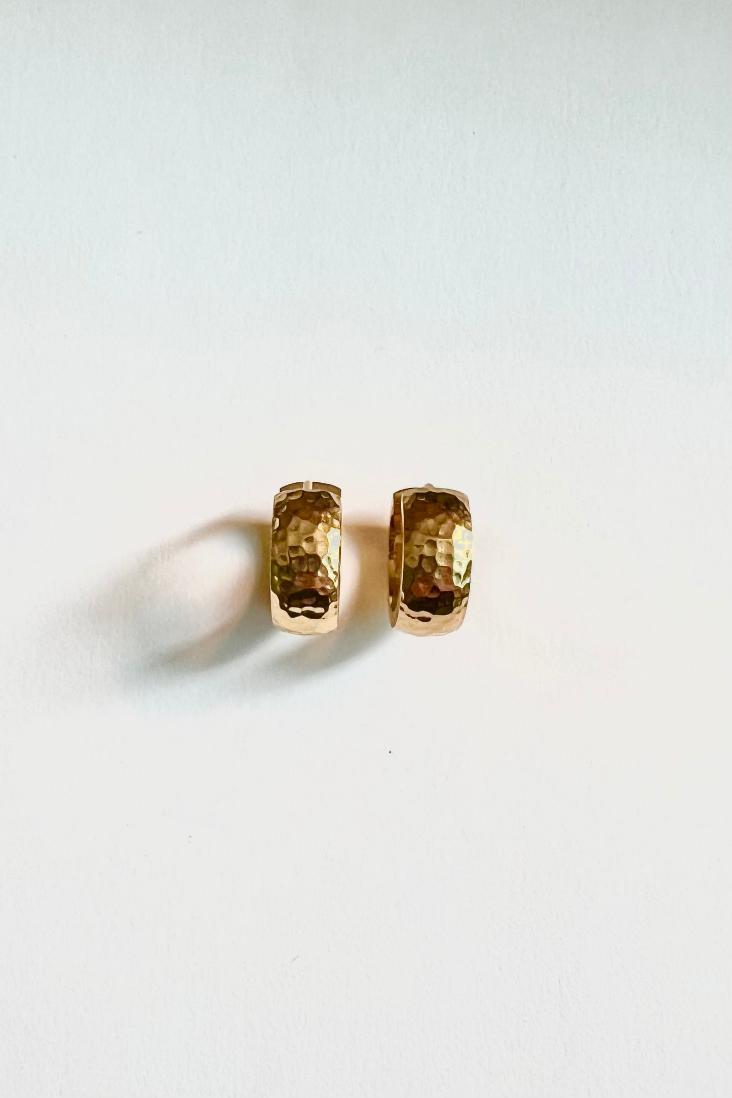 A close up photo of the earrings from the side, highlighting the hammered texture of the earrings.