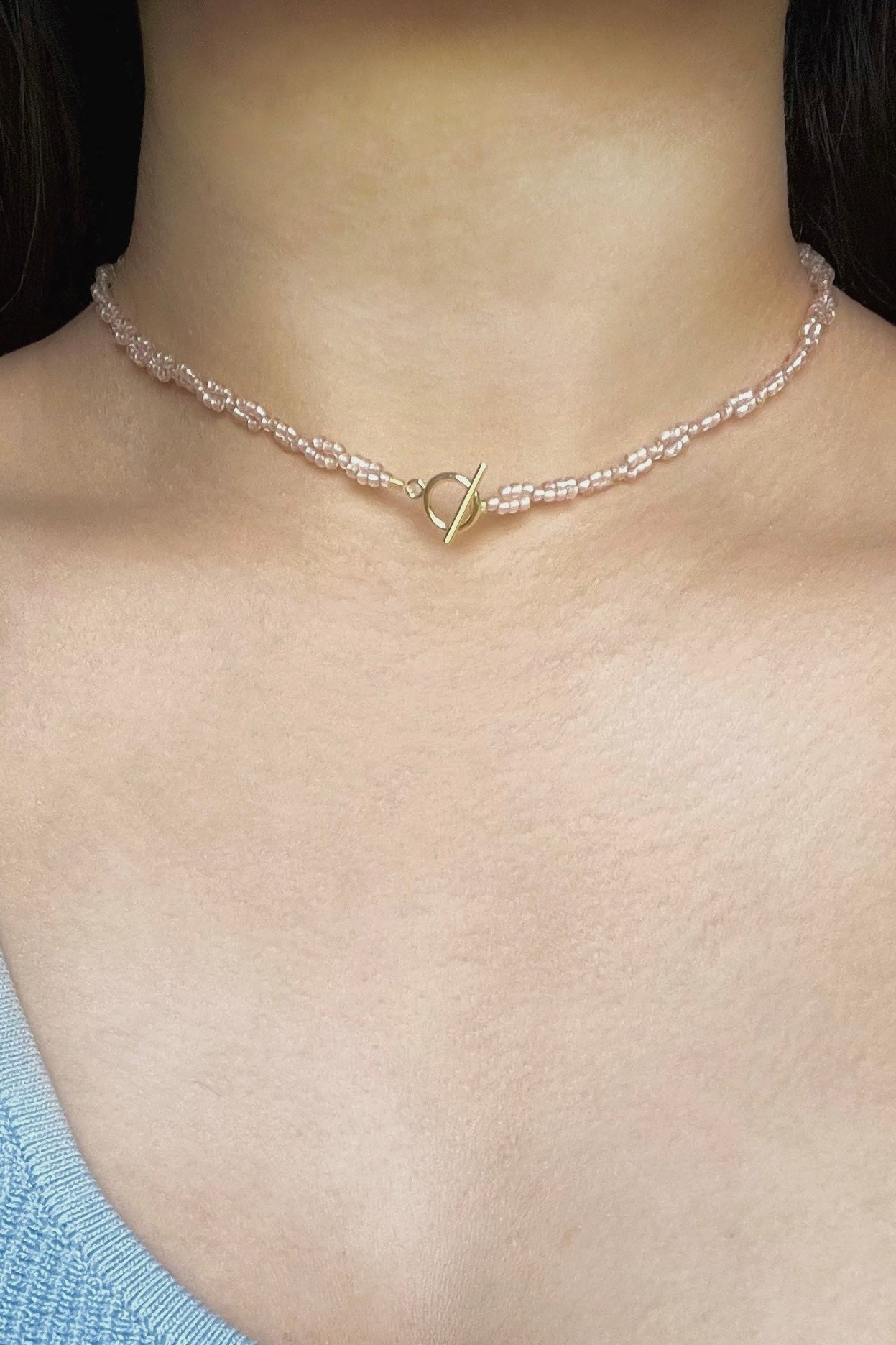 A model wearing the necklace with the gold toggle closure as the center piece.