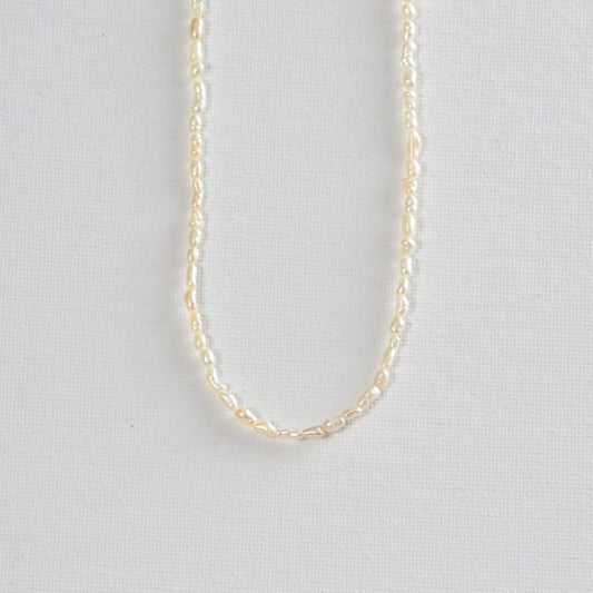 Then rice pearl necklace on a plain white background.