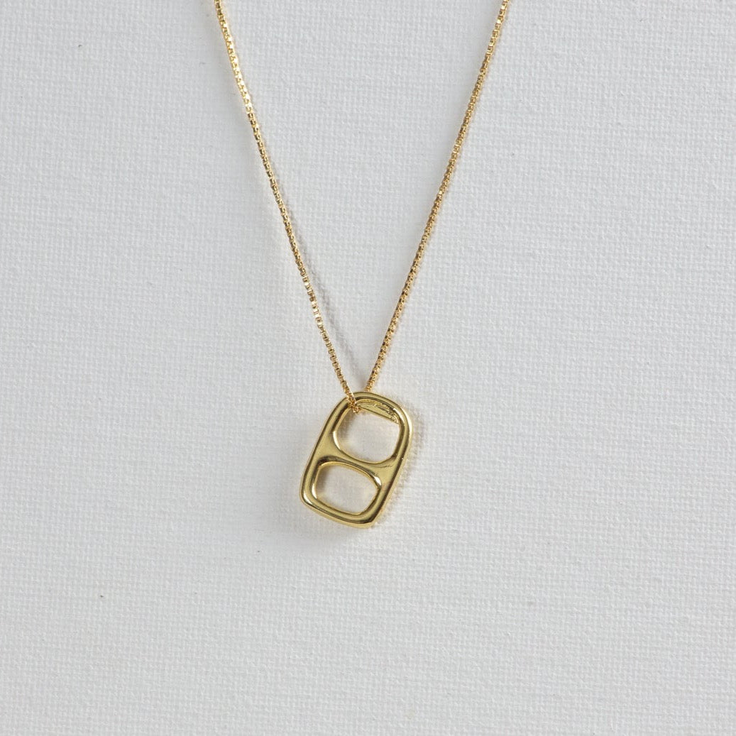 A necklace that features a thin gold chain with the soda tab pendant on a white background.