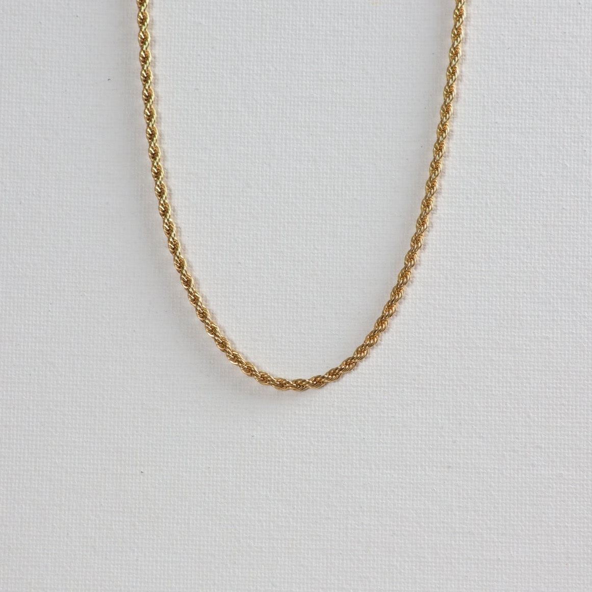 The twisted gold necklace on a white background.