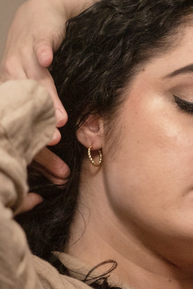 A zoomed, close up photo of a model wearing the earrings, showcasing the true size of the earring.