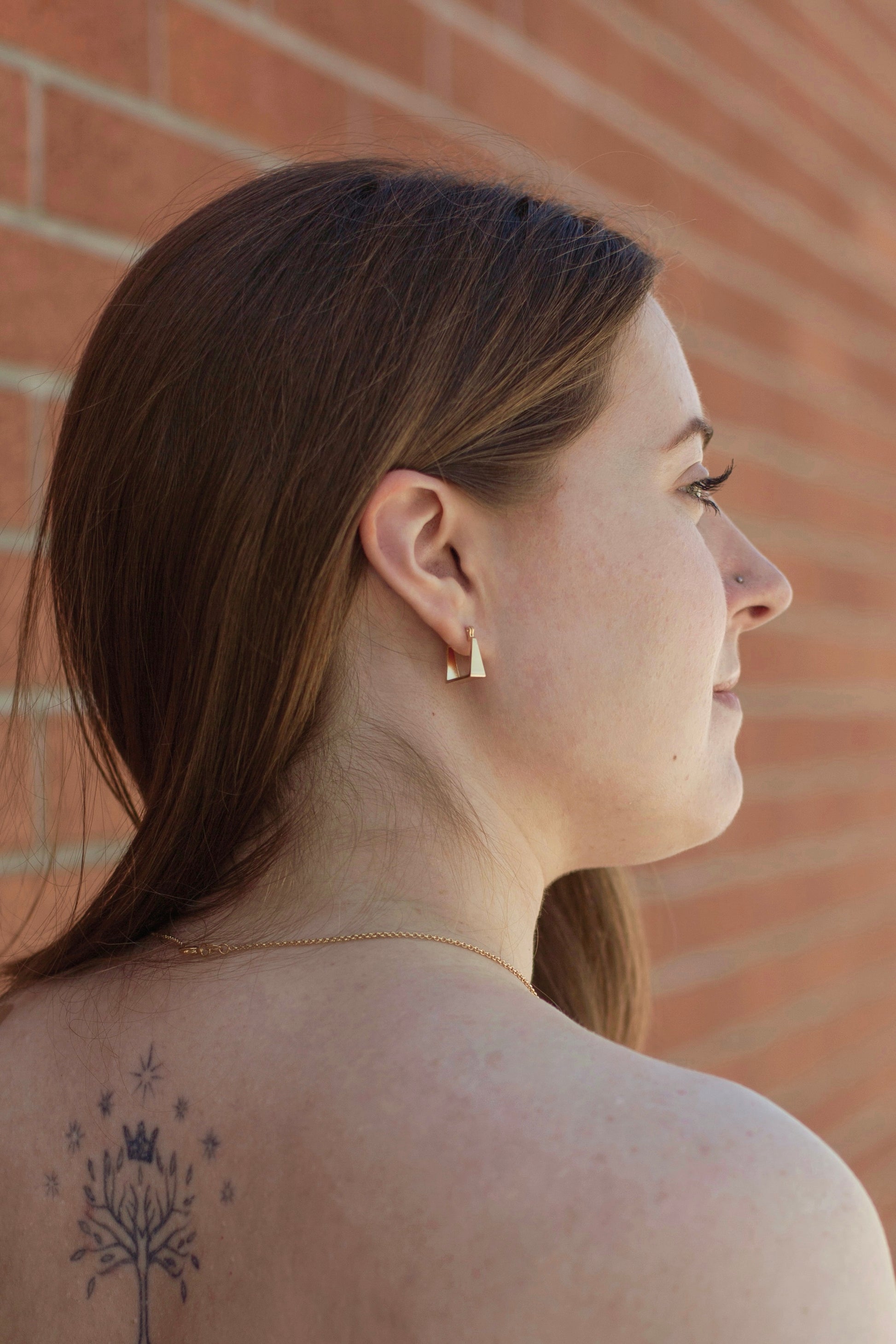 A model waring the earrings. The model is photographed from behind, showcasing how the earring sits on the ear.