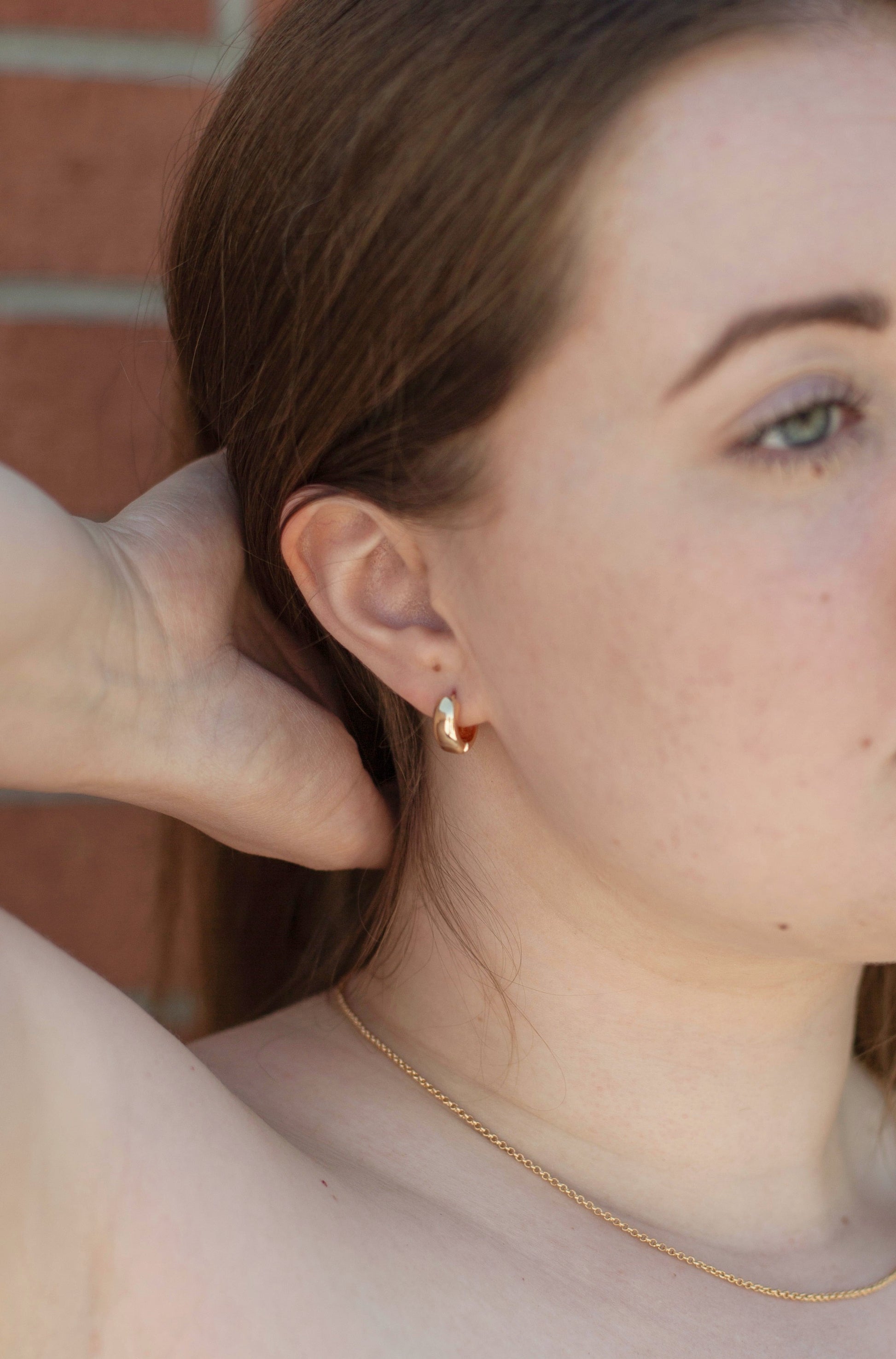 A model swept back her hair showcasing the earring sparkles on her ear.