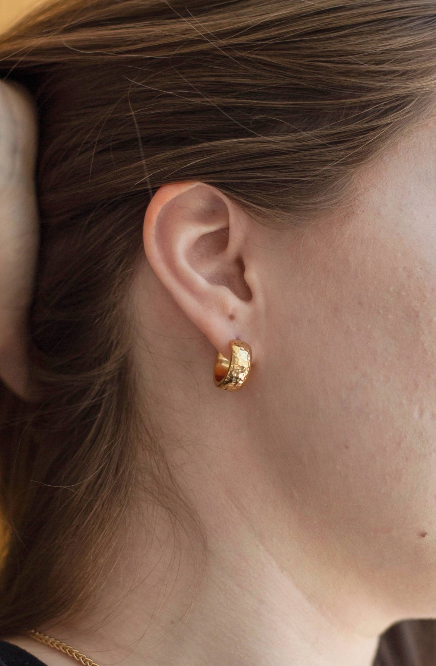 A close up photo of the earring on a model, showcasing how the size and shimmer of the earring.