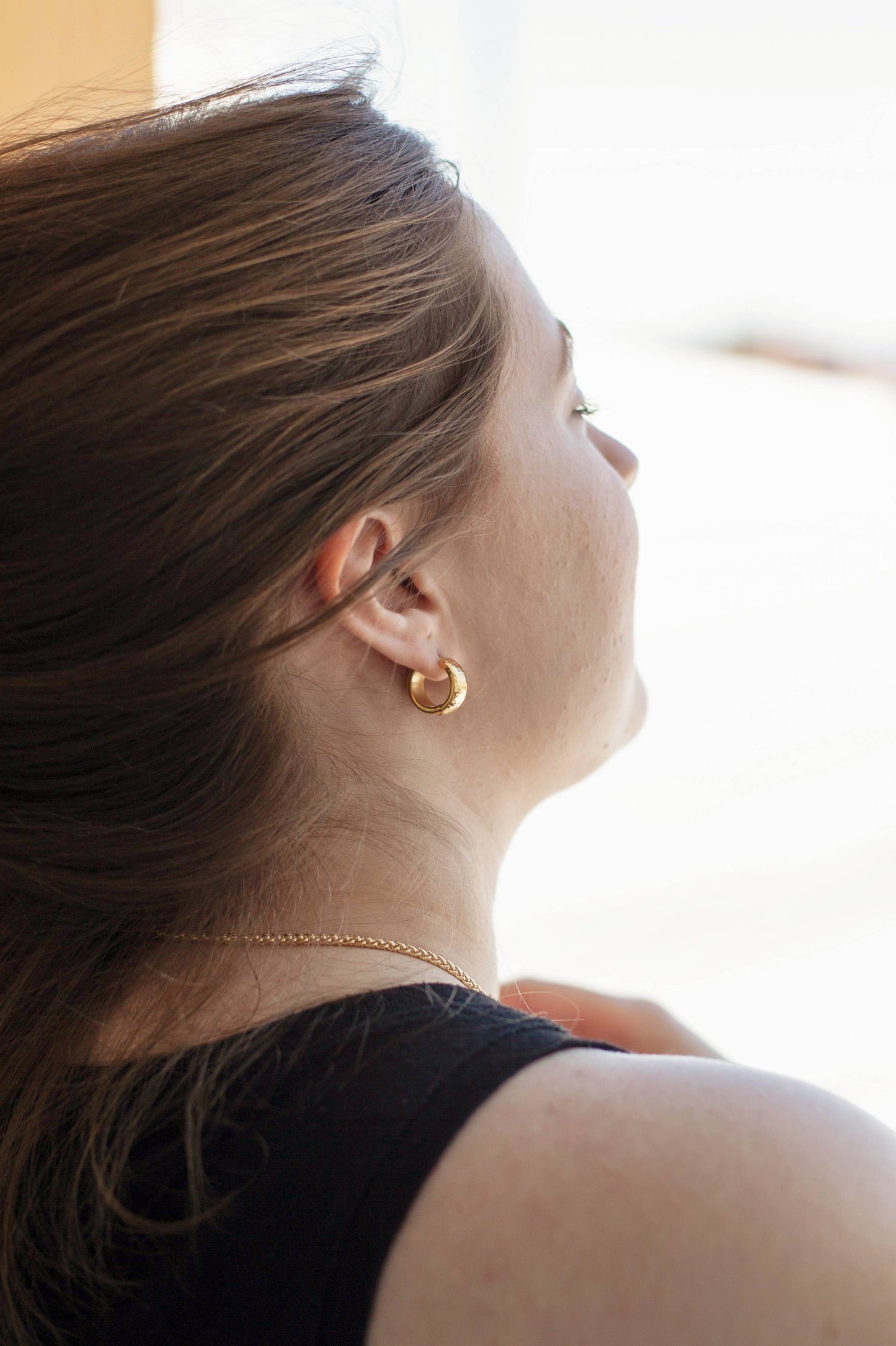 A photo of a model wearing the earring, showcasing the earring size and shape on the ear.