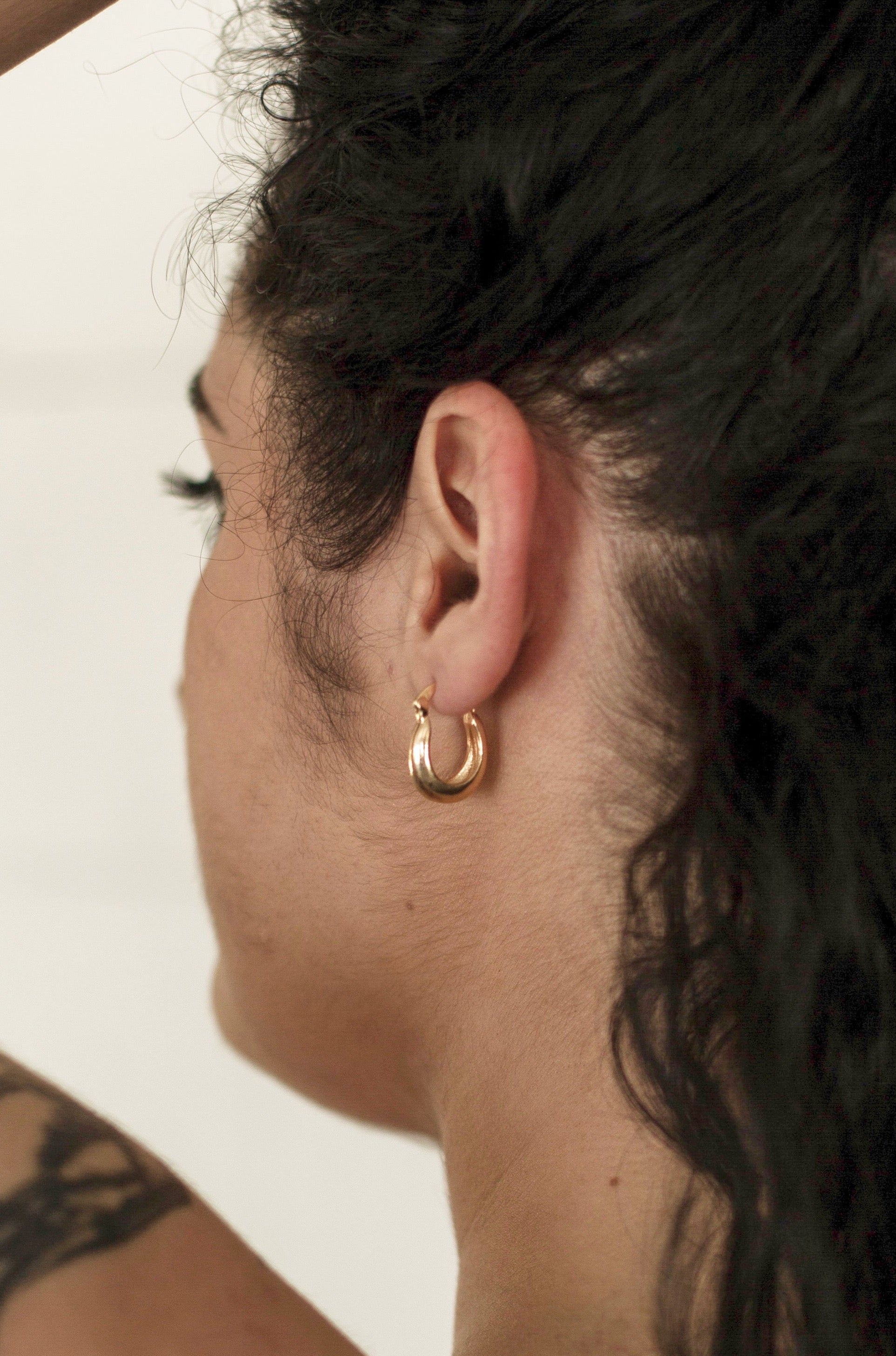 A model wearing the earrings, photographed from behind, showcasing the true size of the earring.