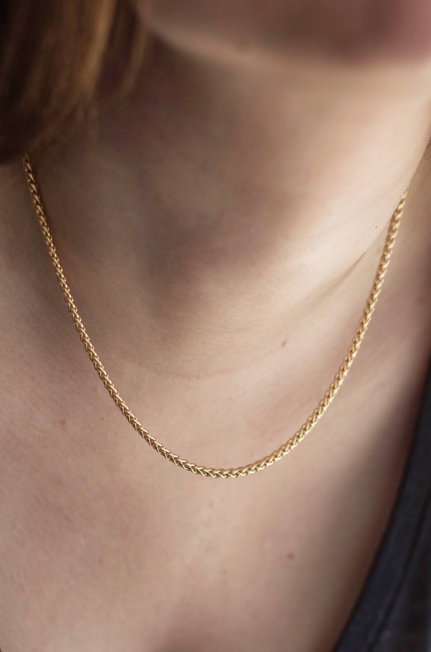 Close up look of a model wearing the necklace, letting the chain effortlessly dangles from her neck.
